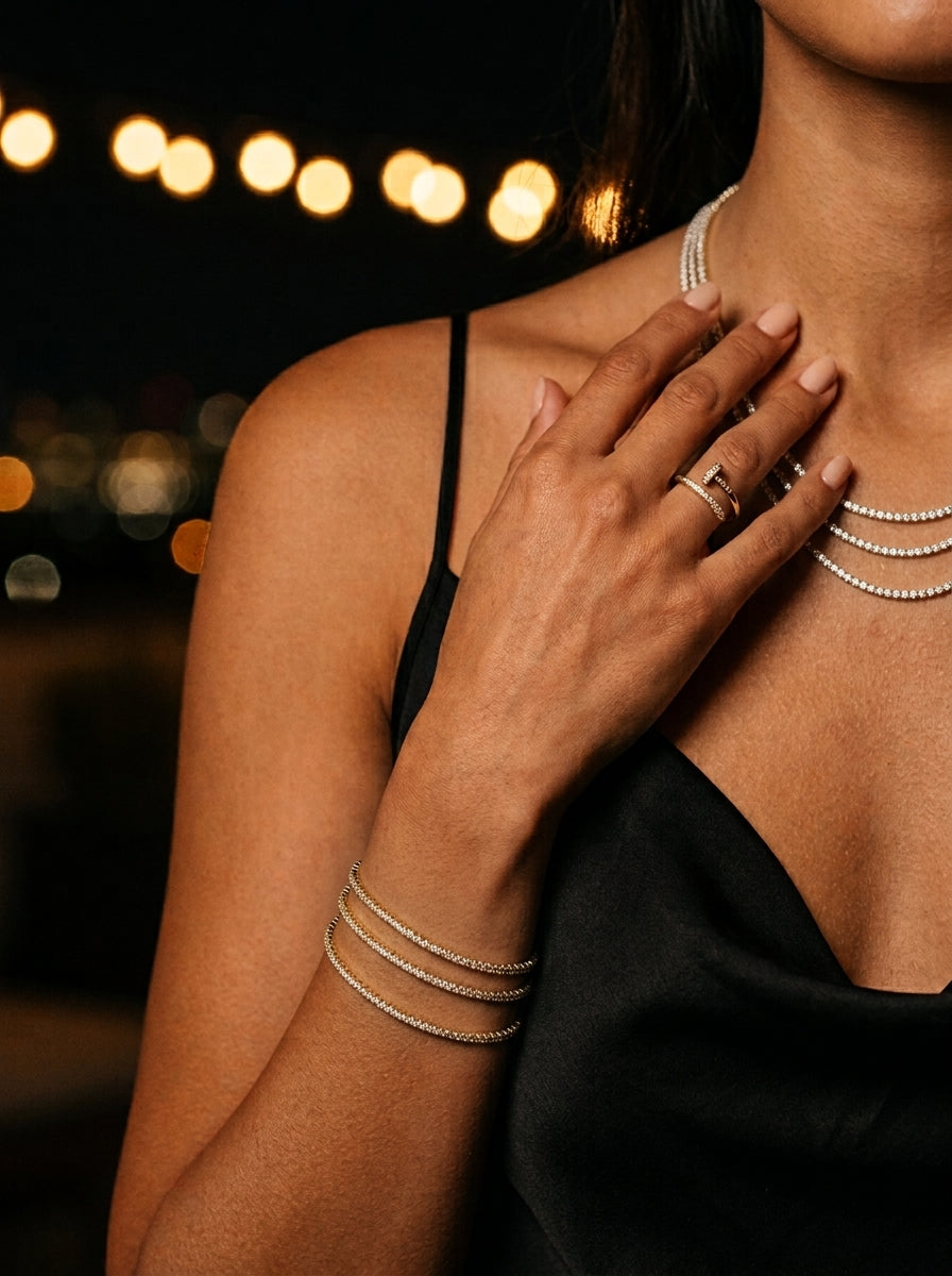 Bracelets Rivière et collier pavé, main posée sur la poitrine, terrasse de nuit